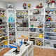 Room with white shelves displaying LEGO collectible models, cars, and figures.