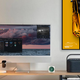 Modern workspace with desktop computer and LEGO car collectible display frame on wall