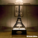 Illuminated display case showcasing a LEGO Eiffel Tower model with a 3D scene base.
